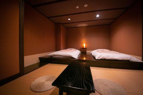 two beds in a room with a mirror at Hosenji Kanko Hotel Yumotoya in Kokonoe