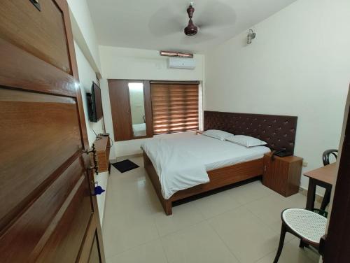 Habitación pequeña con cama y ventana en Thampanoor Tourist Home en Thiruvananthapuram