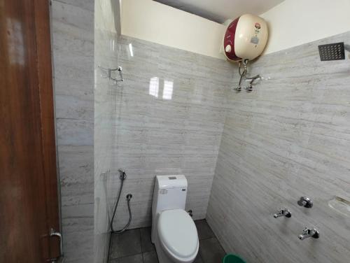 y baño con aseo blanco y ducha. en Thampanoor Tourist Home en Thiruvananthapuram