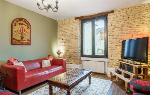 a living room with a red leather couch and a tv at Nice Home In Bayel With Wifi in Bayel