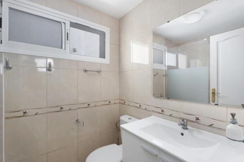 a bathroom with a toilet and a sink and a mirror at Nido Andrea in San Isidro