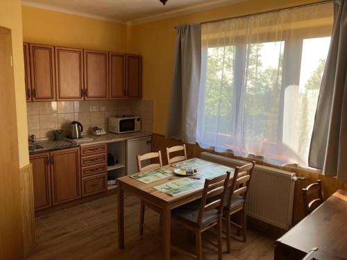 une cuisine avec une table et des chaises ainsi qu'une fenêtre dans l'établissement Vila Limba, à Nový Smokovec