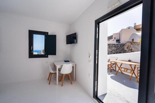 a room with a table and chairs and a window at Caves 1880 in Oia