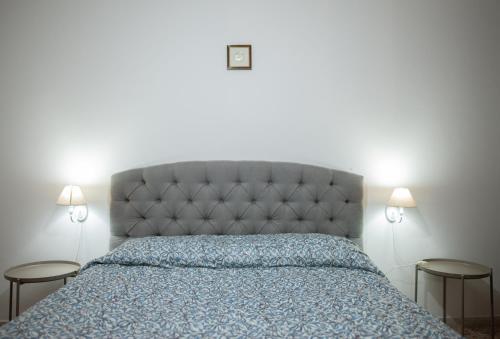 a bedroom with a bed with a blue comforter and two tables at Orlando Bayview in Balestrate