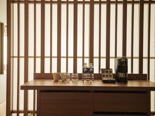 a table with glasses and a coffee maker on it at Asakusa View Hotel Annex Rokku in Tokyo