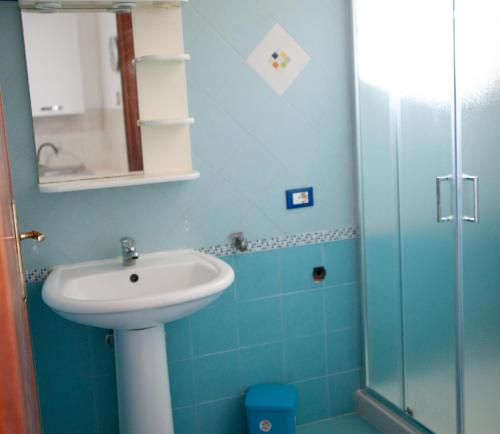 a blue bathroom with a sink and a shower at Orlando Bayview in Balestrate