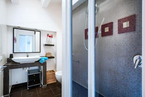 een badkamer met een glazen douche en een wastafel bij Casa Cinzia in Marzamemi