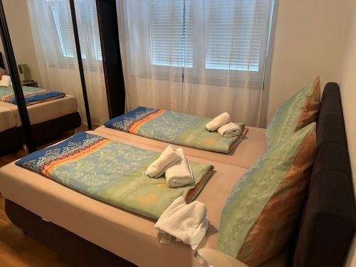 two beds in a room with towels on them at Kevins Ferienwohnungen Uhldingen-Mühlhofen in Uhldingen-Mühlhofen