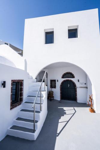 a white building with stairs and a door at Caves 1880 in Oia