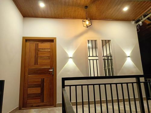 a hallway with a wooden door and a staircase at Paradise Homestay in Wayanad