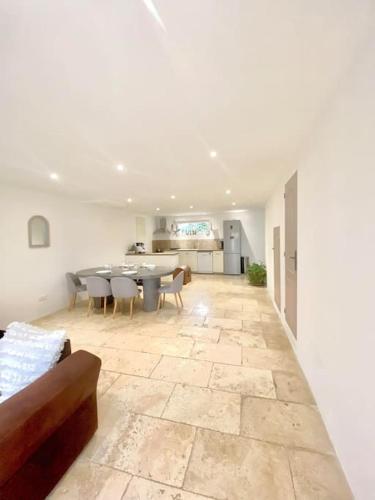 un grand salon avec une table et des chaises dans l'établissement Maison avec jardin et 3 petits chats , proche du Chateau Lacoste, à Le Puy-Sainte-Réparade