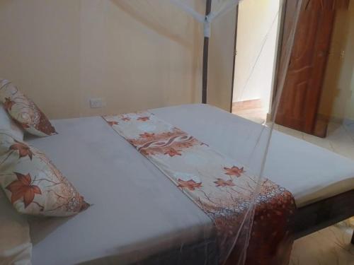 a bed with a comforter and pillows on it at Blessing Holiday Homes - Diani Beach in Diani Beach
