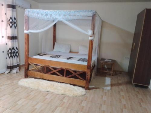 a bed with a canopy in a room at Blessing Holiday Homes - Diani Beach in Diani Beach