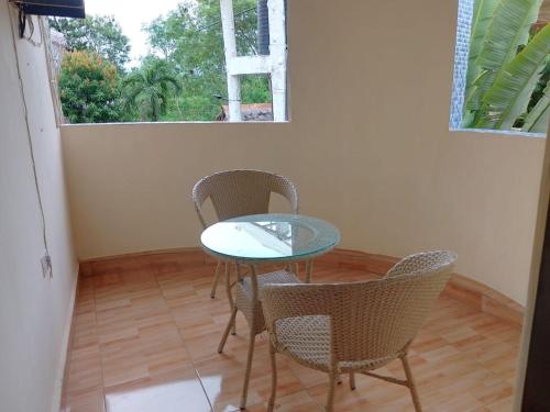a table and chairs in a room with a window at Blessing Holiday Homes - Diani Beach in Diani Beach