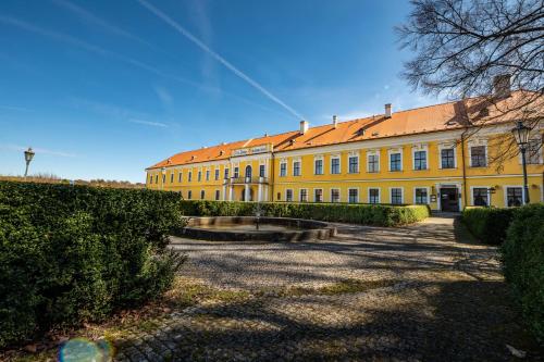 duży żółty budynek z czerwonym dachem w obiekcie Hotel Belcredi w mieście Brno