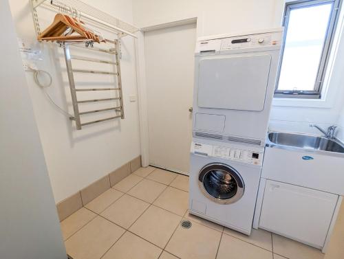 a laundry room with a washing machine and a sink at Jasper 3 in Jindabyne