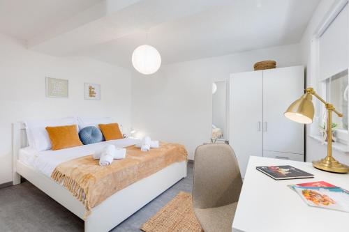a white bedroom with a bed and a desk at Villa Marica Tiny House in Krk city centre in Krk