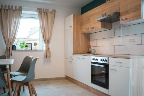 una cocina con electrodomésticos blancos, mesa y sillas en Doppelzimmer 2 - neu renoviert en Dinkelsbühl