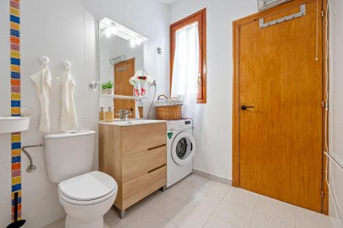 a bathroom with a toilet and a washing machine at Loft El Til-ler in Bellvei del Penedes
