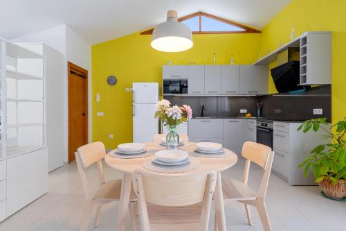 a kitchen with a table and chairs and yellow walls at Loft El Til-ler in Bellvei del Penedes