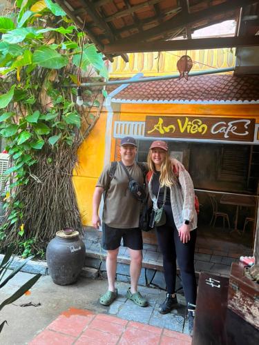 a man and a woman standing in front of a building at An Vien Coffee & Villa in Hoi An