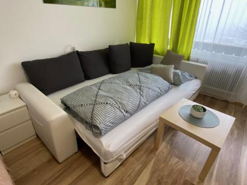 a white couch in a living room with a table at Apartment mit Seeblick in Strobl