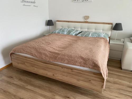 een slaapkamer met een bed met een bruine deken erop bij Apartment mit Seeblick in Strobl