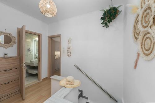 a white bathroom with a hat on the floor at Dennis City Center Elegant Apartment (2) in Zakynthos Town