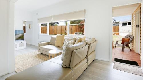 a living room with a couch and a table at Bungalow 21 in Callala Beach