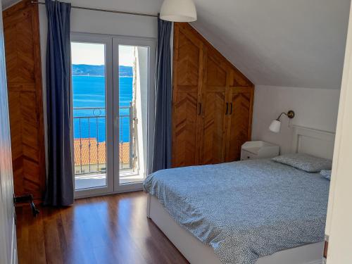 a bedroom with a bed and a large window at Old stone house Klarić in Brela