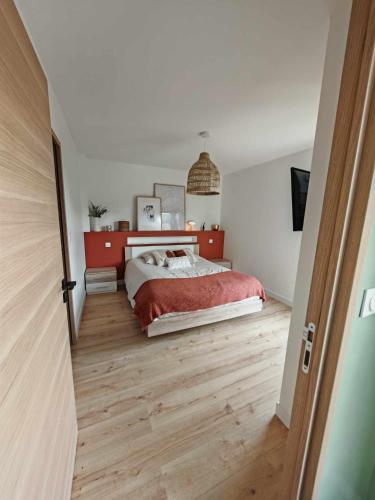 une chambre avec un lit et un parquet dans l'établissement Maison proche circuit Le Mans, à Mulsanne