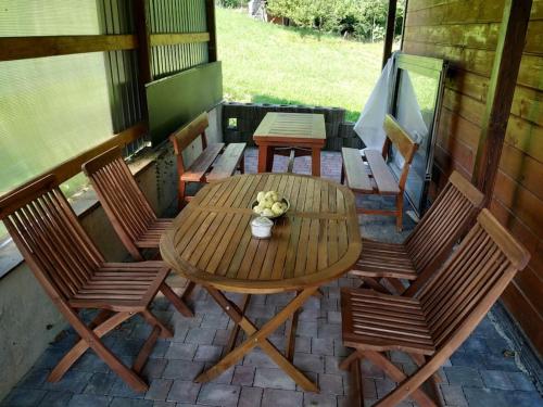 a wooden table and chairs on a patio at Drewniany domek na wynajem Beskid Wyspowy in Limanowa