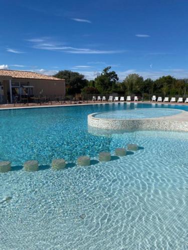 une grande piscine avec des chaises et de l'eau bleue dans l'établissement Les Demeures du Ventoux, à Aubignan