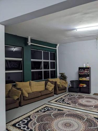 ein Wohnzimmer mit einem Sofa und einem Teppich in der Unterkunft Homestay Koi in Temerloh
