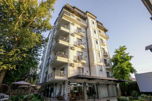 een hoog wit gebouw met balkons bij Moffah Grand Hotel 美华酒店 in Tasjkent
