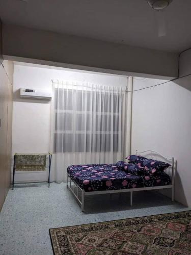 Schlafzimmer mit einem Bett und einem Fenster in der Unterkunft Homestay Koi in Temerloh