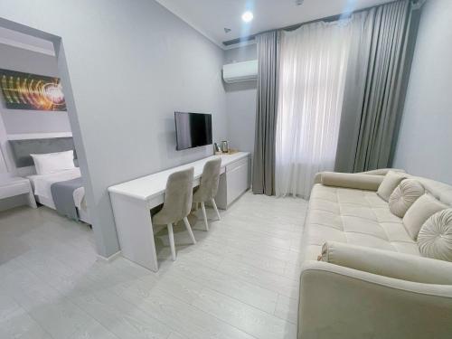 een woonkamer met een bank en een tafel en stoelen bij Moffah Grand Hotel 美华酒店 in Tasjkent