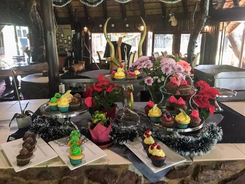 a table with many cupcakes and flowers on it at Ditholo Game Lodge Bela Bela in Bela-Bela