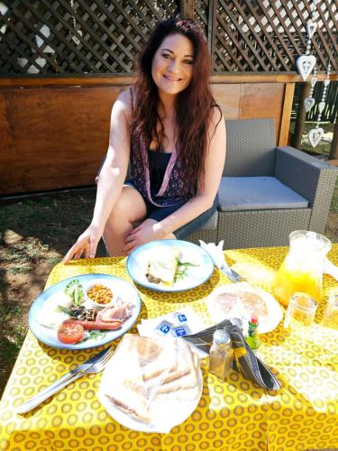 a woman sitting at a table with plates of food at Ditholo Game Lodge Bela Bela in Bela-Bela