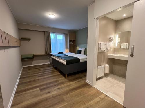 Pokój hotelowy z łóżkiem i łazienką w obiekcie Vingsted Hotel & Konferencecenter w mieście Bredsten