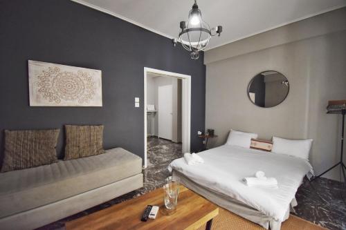 a bedroom with a bed and a couch and a mirror at Suite Tic by Be My Guest in Athens