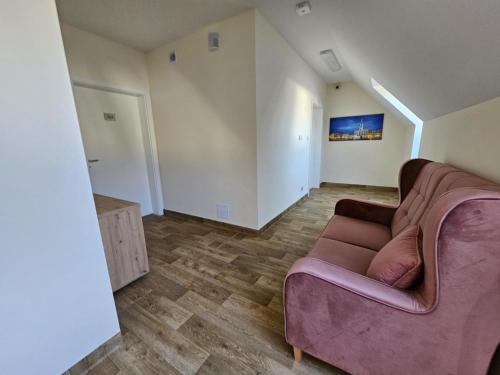 a living room with a purple couch and wooden floors at Sanatorium Rehabilitacyjne im Janusza Korczaka in Krasnobród