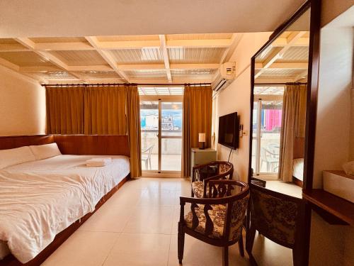 ein Hotelzimmer mit Bett und Balkon in der Unterkunft 雲宿海岸民宿 in Hualien