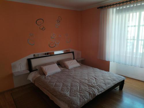 een slaapkamer met een bed met oranje muren bij Apartman Temais in Duga Resa