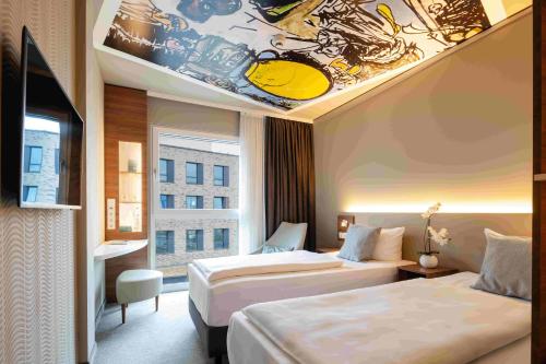 une chambre d'hôtel avec 2 lits et un tableau au plafond dans l'établissement Hey Lou Hotel Monheim am Rhein, à Monheim