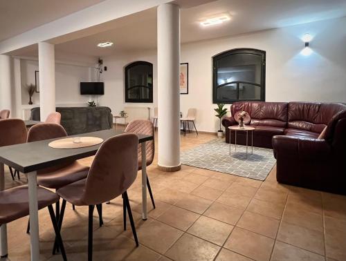 a living room with a couch and a table and chairs at Nussbaum Panzió in Keszthely