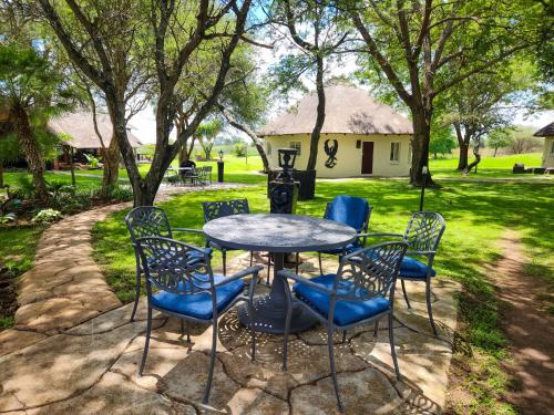 a table and chairs in front of a yard at Ditholo Game Lodge Bela Bela in Bela-Bela