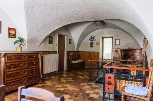 Zimmer mit einem Torbogen, einem Tisch und Stühlen in der Unterkunft Apartma Roner in Podbrdo