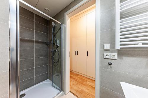 a bathroom with a shower with a glass door at Kora Apartments Andel in Prague