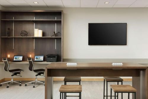 a conference room with a table and chairs and a flat screen tv at Best Western Plus Peppertree Nampa Civic Center Inn in Nampa